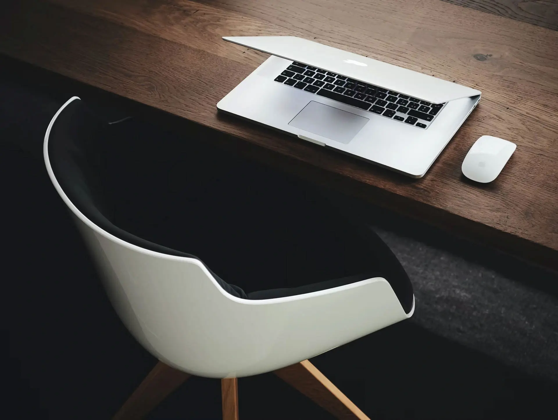 Moderner Arbeitsplatz mit Laptop und Maus auf Holztisch